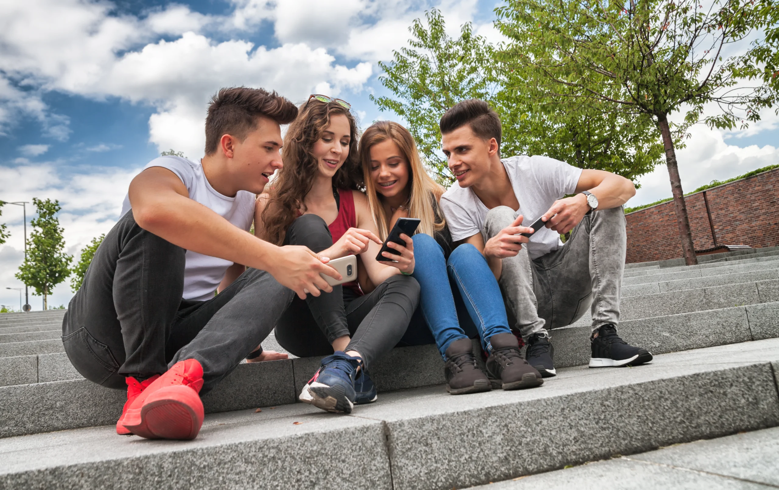 Group of friends sitting together using their phones